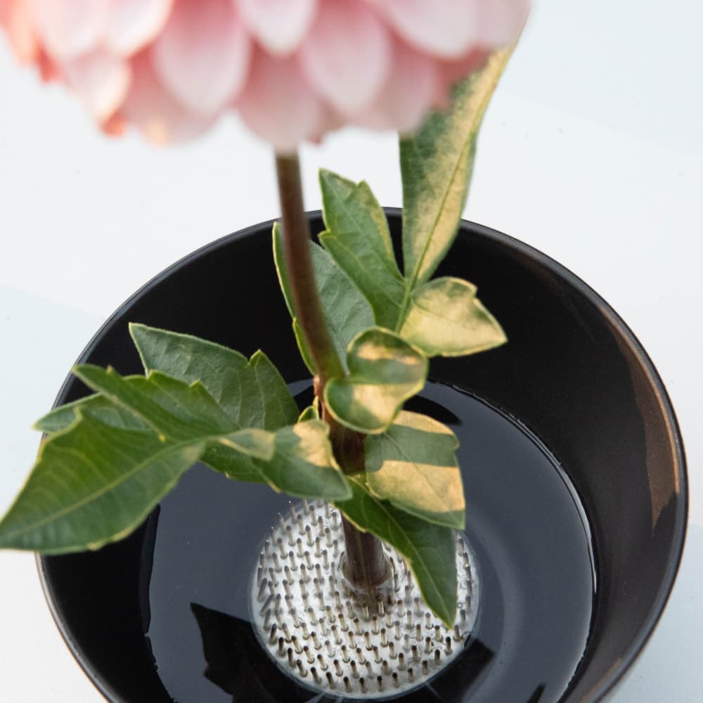 A floral frog in the bottom of a vase